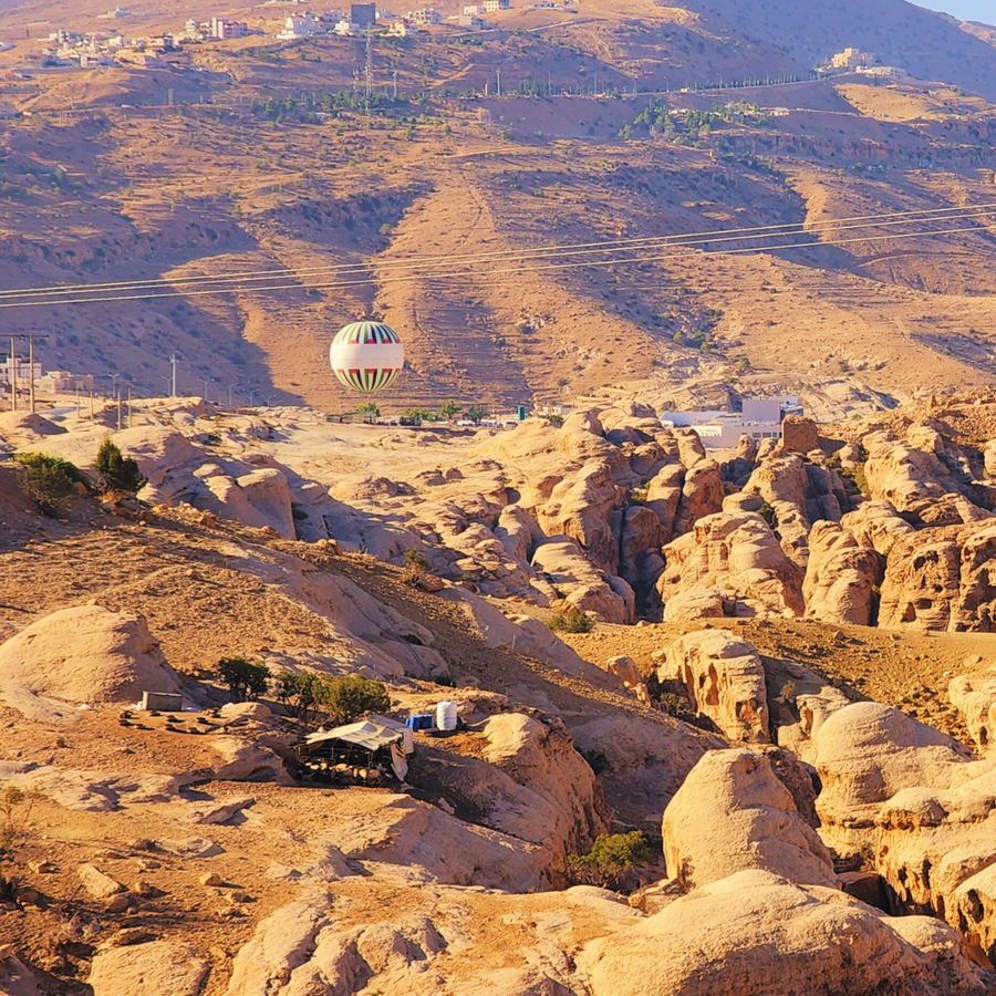 Hot air balloon rising over Wadi Musa and Petra